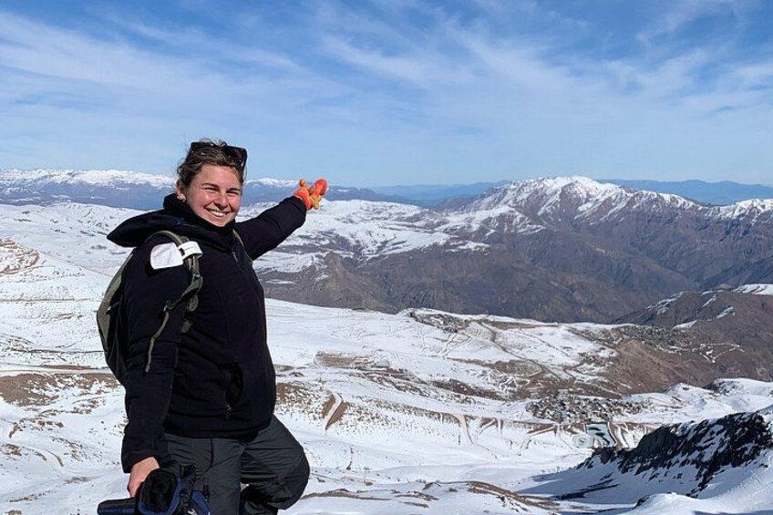 Eine Person auf einem verschneiten Berg mit Rucksack, die in Richtung des Horizonts zeigt. 4
