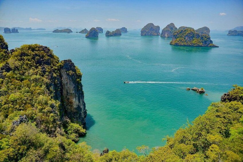 A coastal landscape with clear turquoise water, green vegetation, and several small islands. 5