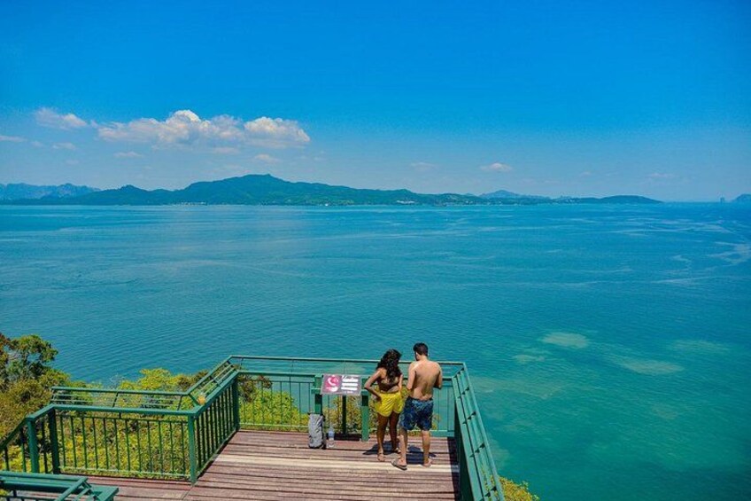 A wooden deck overlooking a large body of water with a distant mountain range. 3