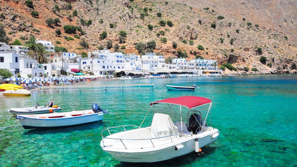 A coastal village with clear turquoise waters, boats, and white buildings. 4