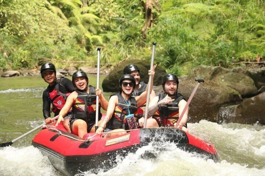 Un groupe de personnes à bord d’un radeau gonflable rouge navigue sur une rivière à courant rapide. 1