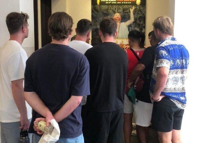 A group of people standing in a line, some holding items. 5
