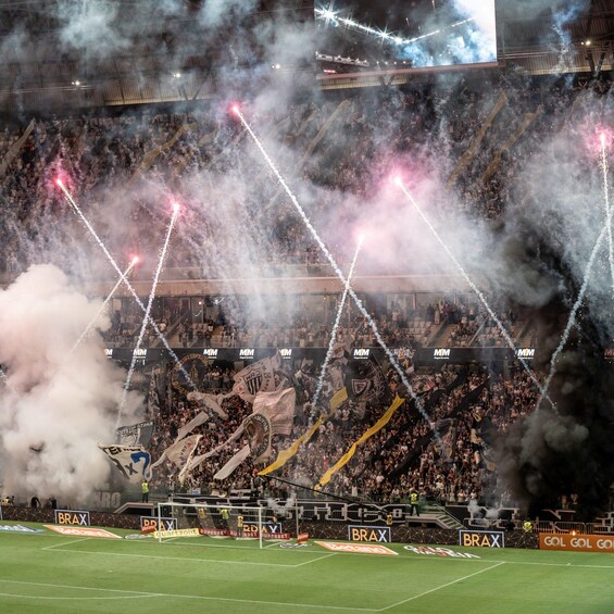 A stadium filled with spectators, smoke effects, and fireworks. 4