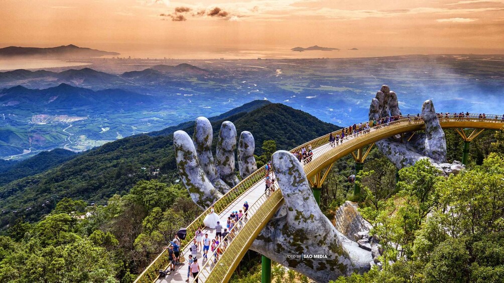 A bridge over a rocky landscape with people walking on it. 5