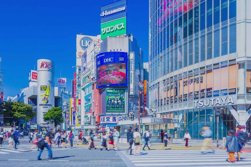 A busy urban street with pedestrians crossing a wide road. 2