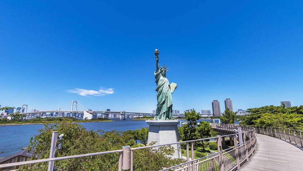 The Statue of Liberty in New York City, with a river and a bridge in the background. 4
