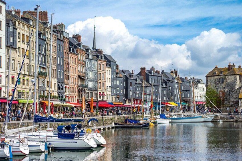 A waterfront with boats docked, colorful buildings, and a clear sky. 3