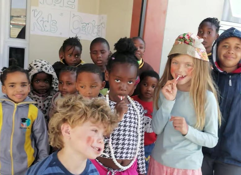 Eine Gruppe von Kindern steht vor einem Schild mit der Aufschrift 'Kids Center'. 3