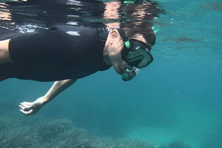 Une personne nageant sous l’eau, équipée d’un tuba et de lunettes de plongée. 3