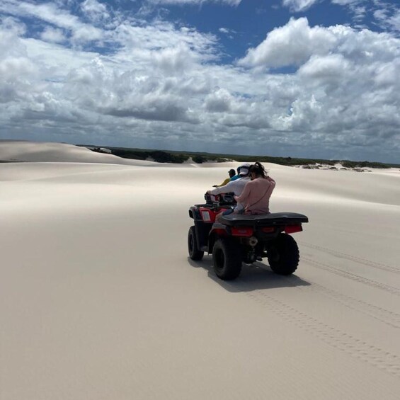 A quad bike on a sandy dune with a cloudy sky. 4