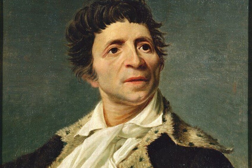 A person wearing a dark coat with a white shirt and a fur collar. 2