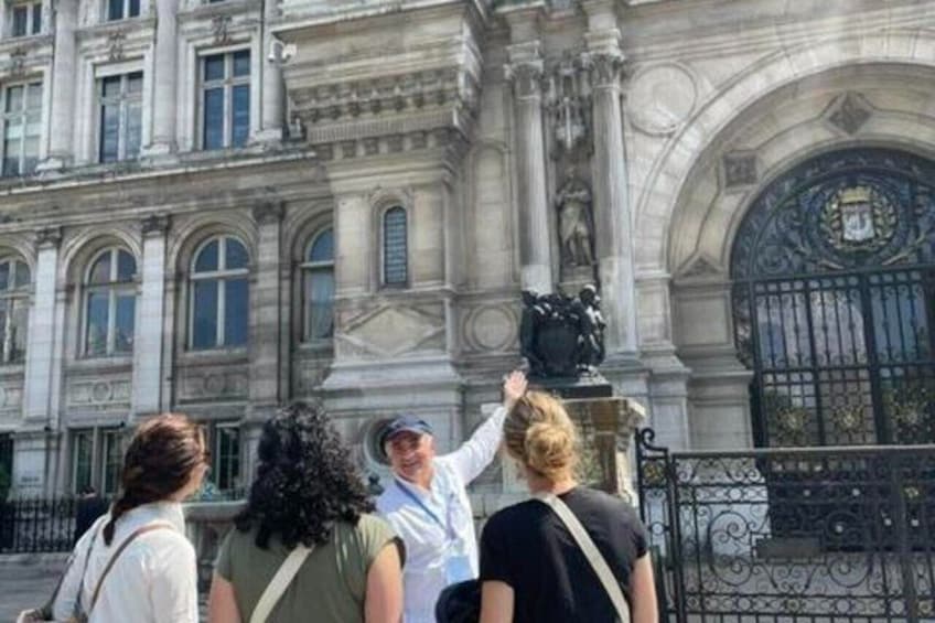 Un gruppo di persone in piedi di fronte a un edificio storico con architettura elaborata e una statua. 2
