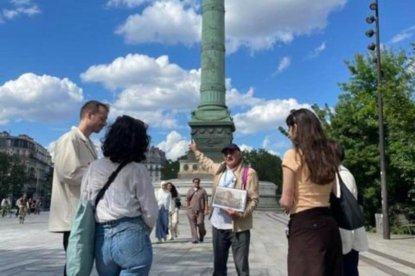 Un gruppo di persone in una piazza pubblica, con un monumento imponente sullo sfondo. 3