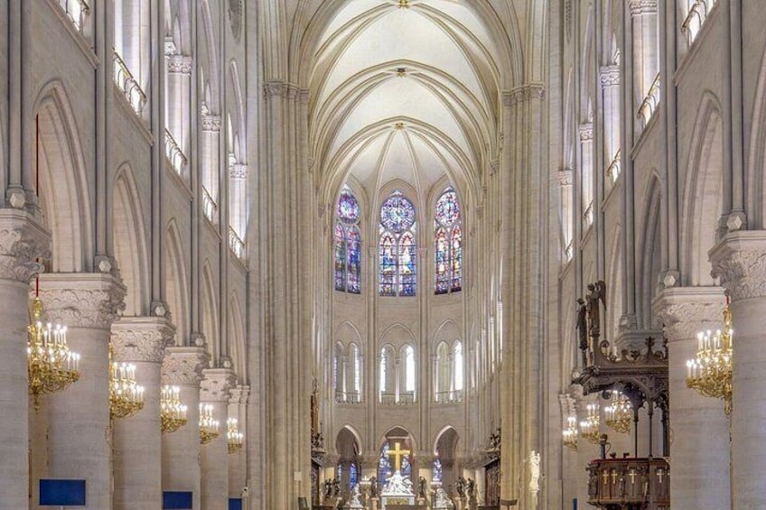 A cathedral interior with high vaulted ceilings, stained glass windows, and ornate chandeliers. 3