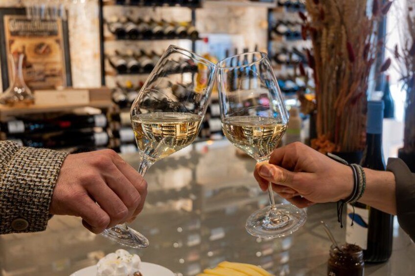 Twee personen proosten met wijnglazen in een bar. 4