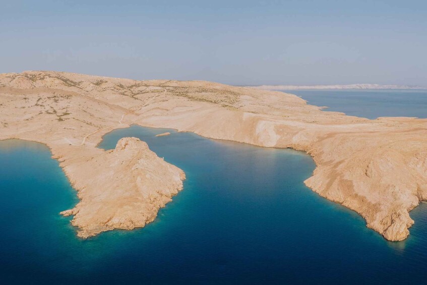 A coastal landscape with a large body of water and sandy terrain. 4