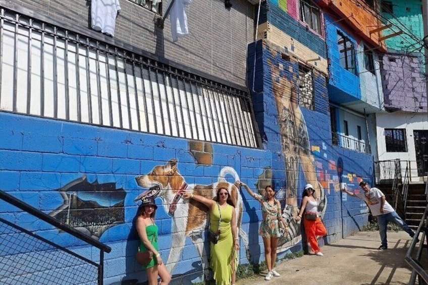 Un murale raffigurante un cane su un muro blu, con persone che scattano una foto davanti. 3