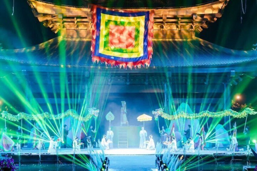 A traditional stage with performers, a dragon, and a large emblem. 3