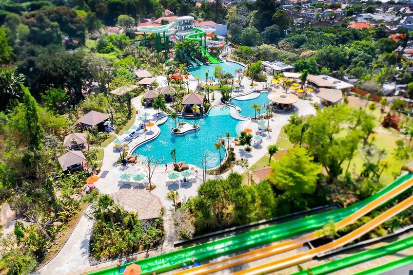 A water park with a large pool, slides, and umbrellas. 1