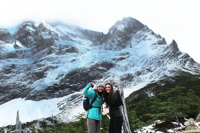 Dos personas frente a una montaña nevada con un glaciar. 3