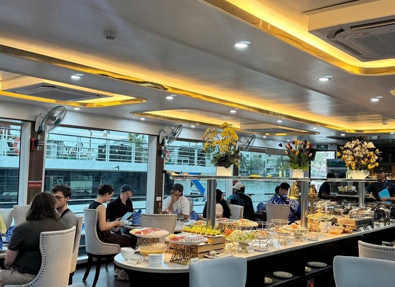 A restaurant with a buffet, people dining, and a view of the water. 4