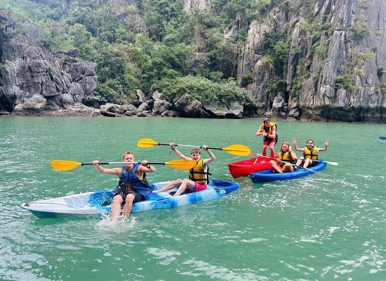 People kayaking on a calm river surrounded by rocky cliffs. 2