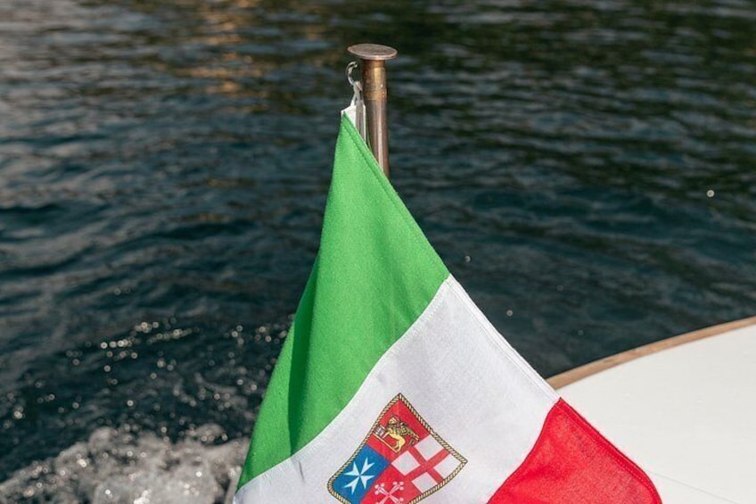 A flag with a coat of arms, a green field, white field, and red field. 2