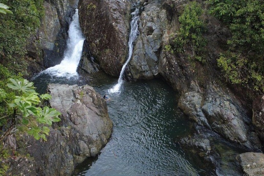 A waterfall cascading over rocks in a forested area. 2
