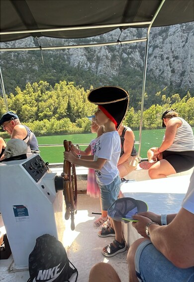 A group of people on a boat with a mountainous landscape in the background. 5