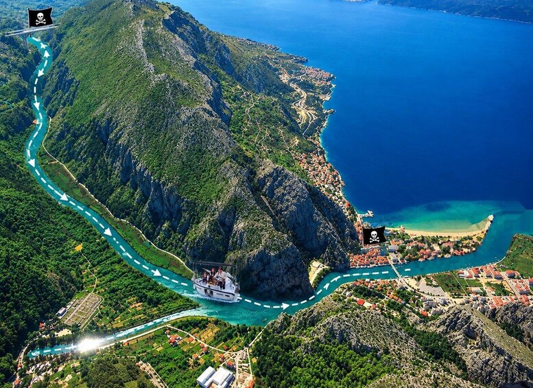 A coastal road winding through a mountainous landscape with a boat on the water. 1
