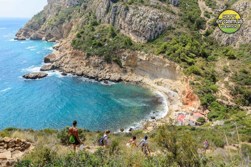 A coastal landscape with cliffs, a beach, and a small settlement. 1
