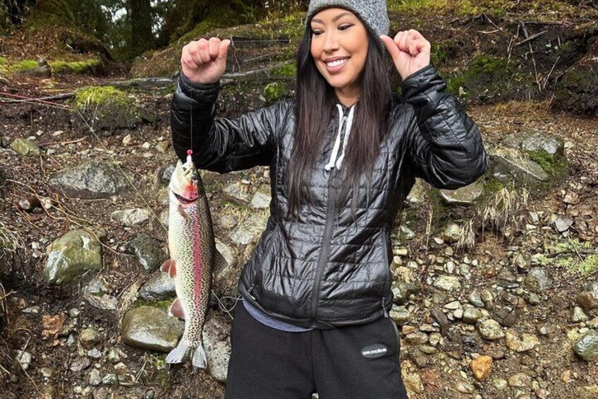 A person holding a fish in a rocky outdoor setting. 2