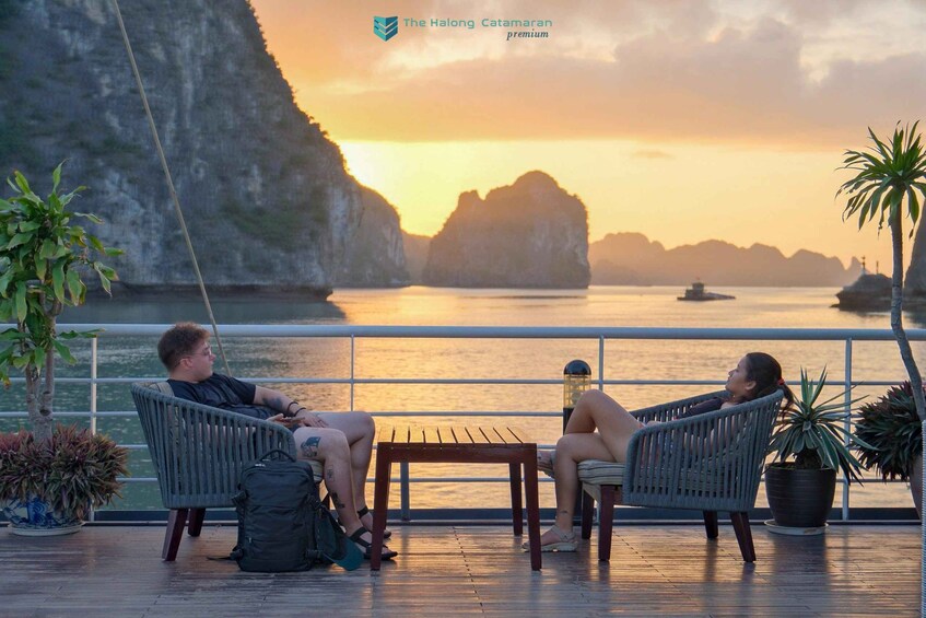 Dos personas descansando en sillas de mimbre frente al agua al atardecer. 2