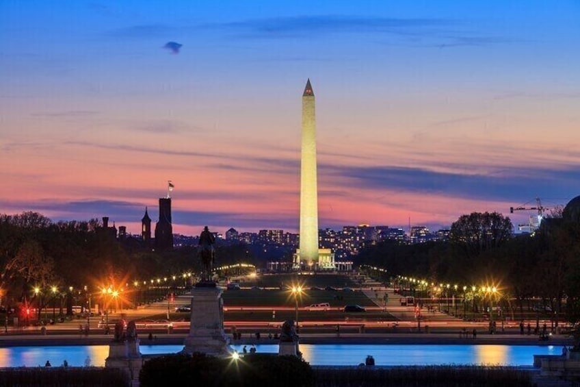 The Washington Monument at dusk with city lights in the background. 4