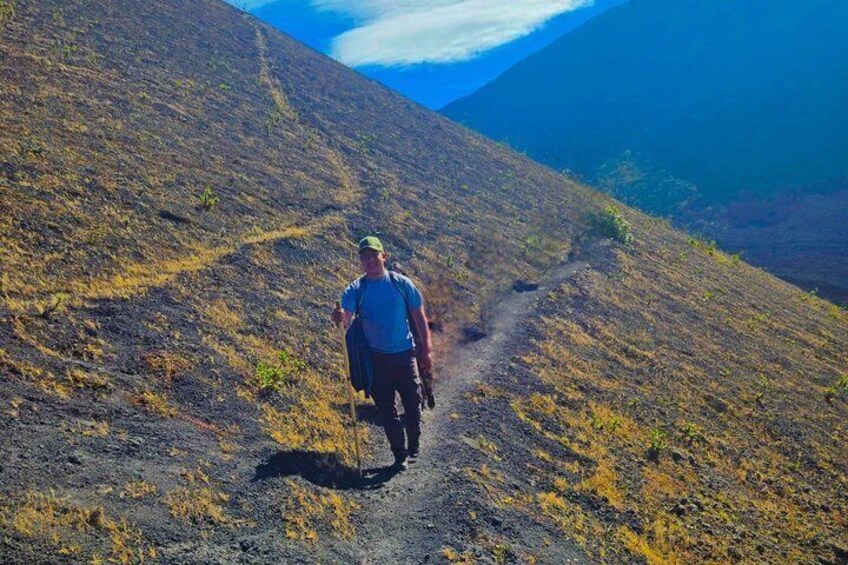 Ein Wanderer geht auf einem Feldweg in einer bergigen Landschaft. 2