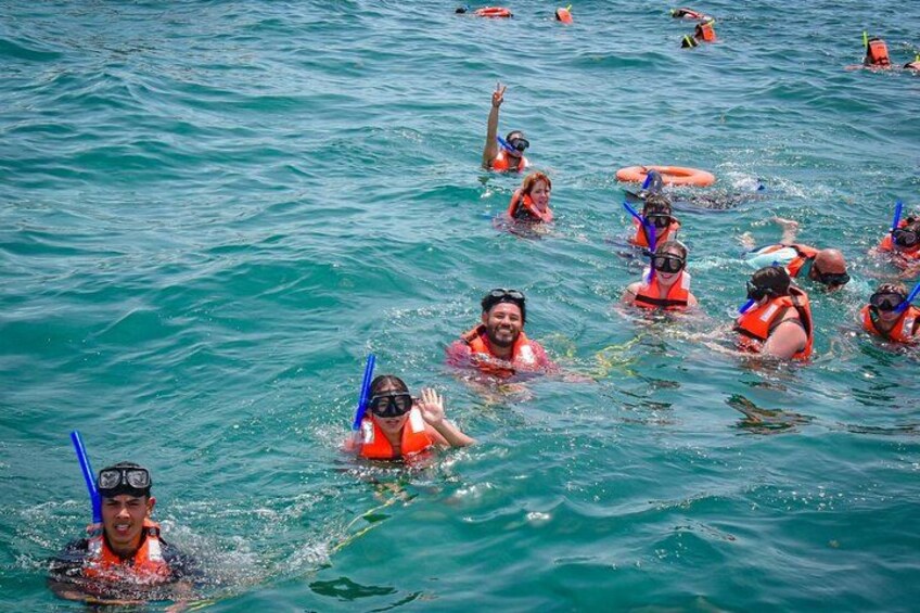 Un grupo de personas haciendo snorkel en aguas azules y cristalinas. 2