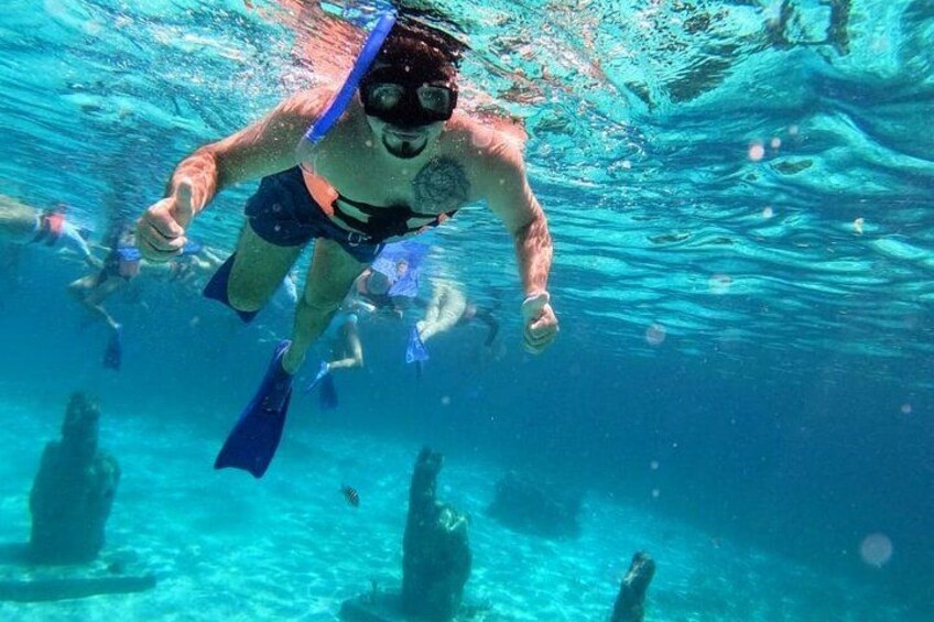Una persona bajo el agua con aletas, rodeada de agua azul cristalina. 3