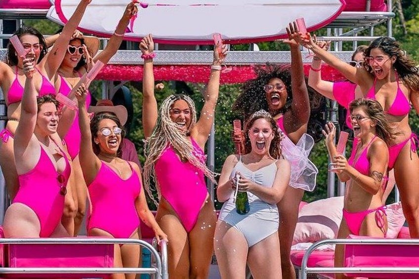 Un groupe de personnes vêtues de maillots de bain roses, célébrant l’événement autour de boissons. 4