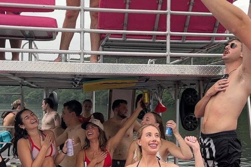 Un groupe de personnes se trouve sur un bateau, muni d’une rambarde en métal et surmonté d’un auvent rouge. 3
