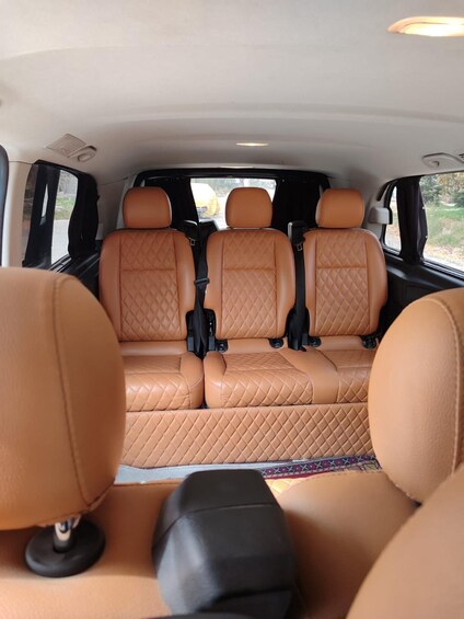 A car interior with tan leather seats and a quilted pattern. 2