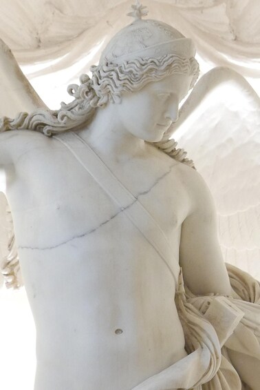 A marble statue of a figure with wings, draped clothing, and a detailed headdress. 2