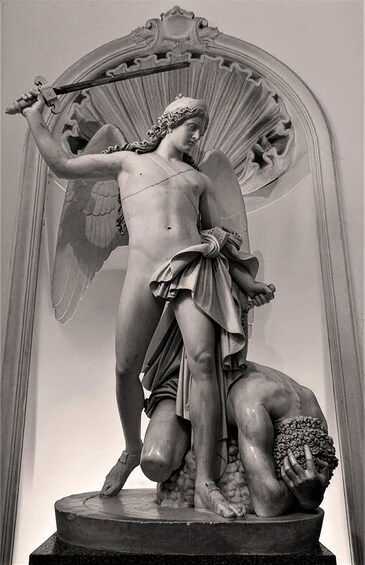 A classical statue of an angel holding a sword, standing on a pedestal with a draped cloth. 3