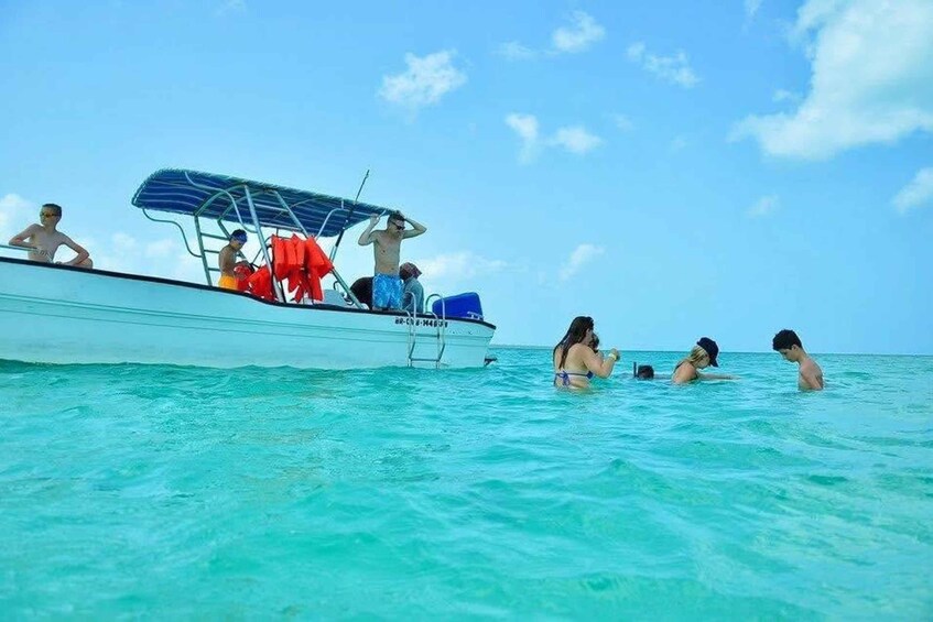 A boat with people swimming in the ocean. 3