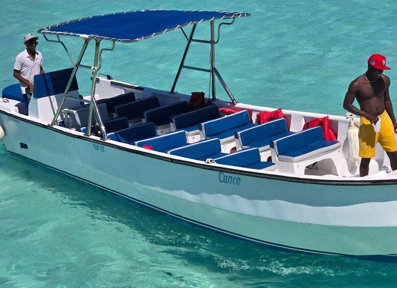 A boat with blue and white seating, a canopy, and two people on board. 5