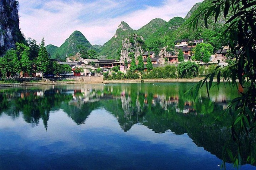 A calm lake reflecting buildings and mountains. 4