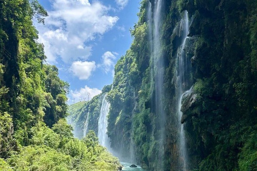 A waterfall cascading down a lush green cliff. 5