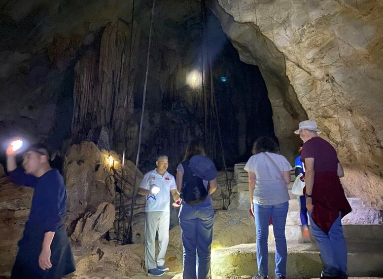 A group of people exploring a cave with artificial lighting. 2