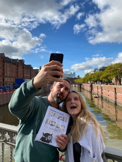 A person holding a book titled 'PERSON GALLERY' with a cityscape in the background. 1
