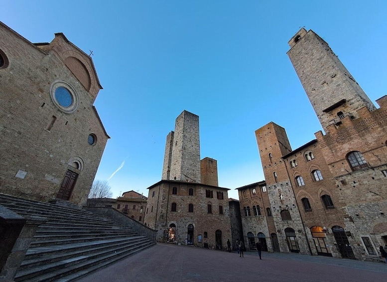 A historic square with a church, a bell tower, and a staircase leading up to the entrance. 5