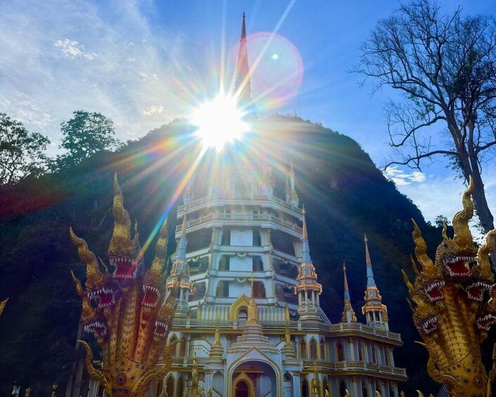 A grand, multi-tiered temple with golden statues and a clear sky. 2